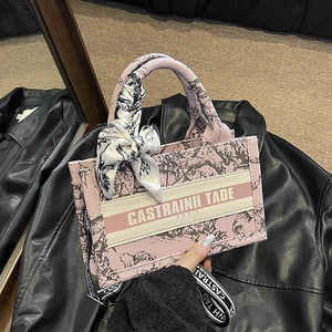 Pink canvas tote bag with floral toile print, striped band, and decorative silk scarf