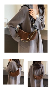 Detail of dark brown suede crescent bag with gold chain and knot leather strap detail