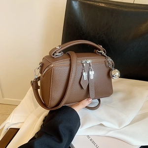 Sac Boston marron en cuir grainé avec bandoulière et pendentif boule argentée
