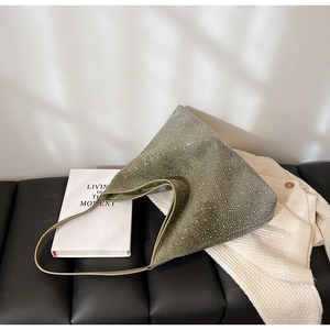 Sac hobo vert sauge à strass finition daim sur banc en cuir avec accessoires de style