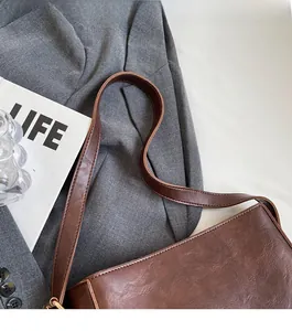 Gros plan sur le cuir marron texturé et les détails dorés du sac seau vintage