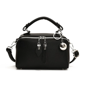Sac Boston chic en cuir grainé noir avec breloque boule argentée et bandoulière réglable