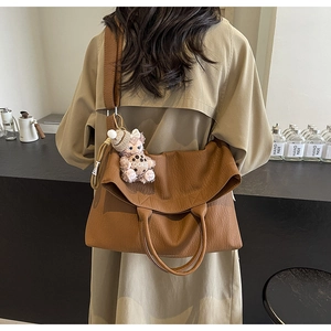 Detail of caramel tote bag with lychee texture and cute plush cookie dog charm
