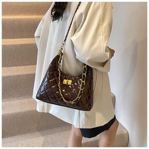 Close-up of dark brown quilted hobo bag featuring glossy finish and gold chain strap