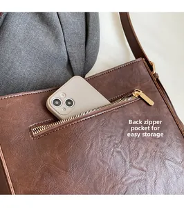 Détail de la poche zippée fonctionnelle au dos du sac seau en cuir marron pour le rangement