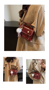 Detail of dark red patent leather shoulder bag with gold studs and plush doll charm