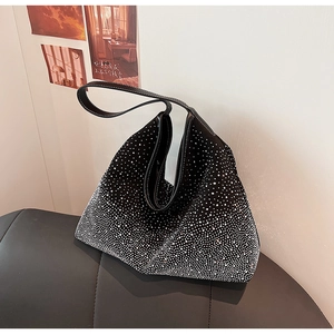 Macro des strass argentés en dégradé et coutures contrastées sur un sac fourre-tout