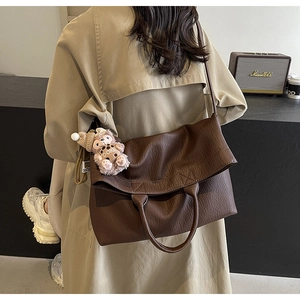 Close-up of large brown lychee grain tote bag with a cute plush puppy charm