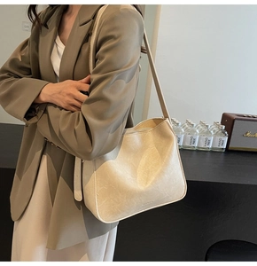Détail d'un sac seau blanc crème avec texture imitation pierre et fine bandoulière en cuir