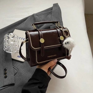 Retro dark brown glossy leather flap shoulder bag with gold buckle and plush charm