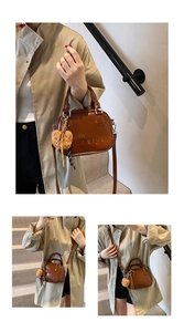 Detail of a brown glossy leather small square bag with double handles and plush heart pendant