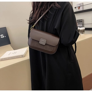 Detail of a brown leather crossbody bag featuring suede textures and a branded MUCOO buckle