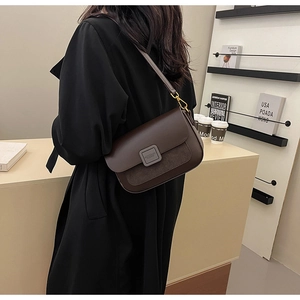 Detail view of a vintage dark brown shoulder bag with mixed leather and suede textures