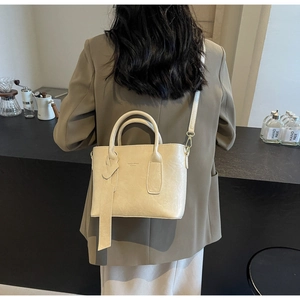 Détail du sac seau en cuir blanc crème avec poignées et fine bandoulière réglable