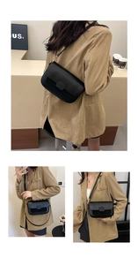 Detail of black rectangular crossbody bag with golden hardware and adjustable strap