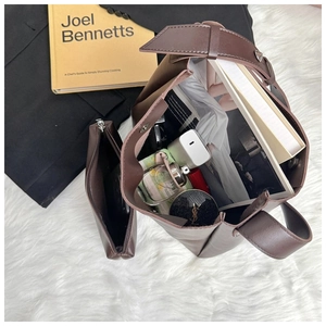 Detail view of large dark brown tote bag capacity with inner pouch and office essentials