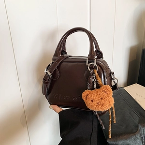 Minimalist dark brown glossy crossbody bag with bear charm and top handle