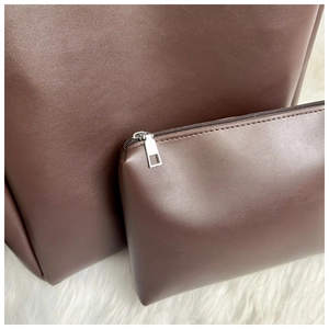 Detail of vintage brown leather tote bag with matching inner pouch and silver zipper