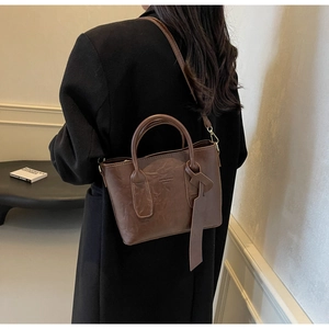 Sac seau vintage en cuir plissé marron, vue latérale porté par un mannequin