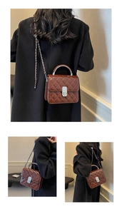 Détail du sac bandoulière matelassé marron foncé avec poignée métallique et chaîne