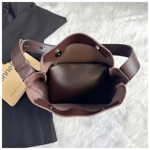Close-up of brown leather bucket tote with internal zipper pouch and magnetic closure