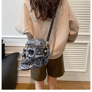 Gothic skull crossbody bag with rock texture and glitter strap shown on model shoulder