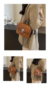 Détail d'un sac bandoulière matelassé marron avec poignée anneau argentée et bandoulière