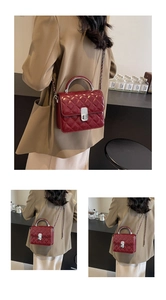 Détail du sac à bandoulière matelassé rouge avec poignée argentée et sangle de chaîne