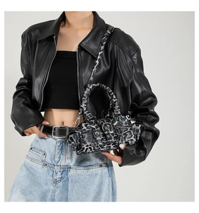 Detailed shot of leopard print Boston bag with metallic buckles on a fashion model
