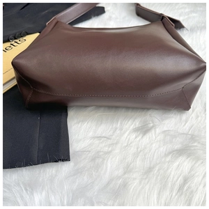 Detail view of large dark brown leather hobo bag with wide shoulder strap and reinforced stitching