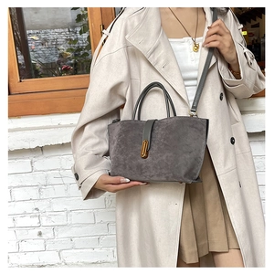 Détail du sac cabas en daim gris foncé avec élégante boucle en métal doré et bandoulière en cuir