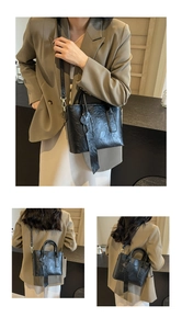 Gros plan du sac seau noir vintage en cuir ciré avec détails dorés et breloque cœur