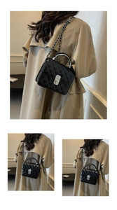 Détail du sac à chaîne matelassé noir avec poignée en métal argenté et fermoir rotatif
