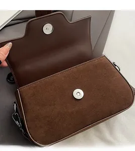 Détail du sac en cuir mat marron foncé avec fermoir magnétique et anneau métallique