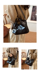 Dettaglio borsa a mano in pelle nera lucida con mini lucchetto decorativo e tracolla