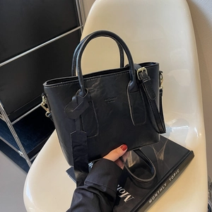 Sac seau chic en cuir noir avec poignées supérieures et bandoulière réglable pratique