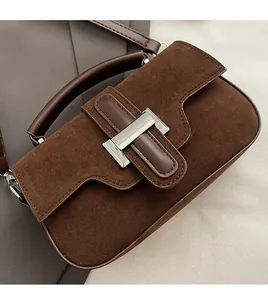 Vue détaillée du sac en daim marron foncé avec fermoir en métal argenté et coutures précises