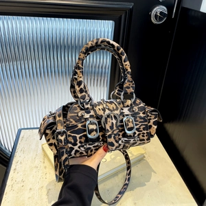 Vintage leopard print Boston bag with rivets and adjustable straps in hand