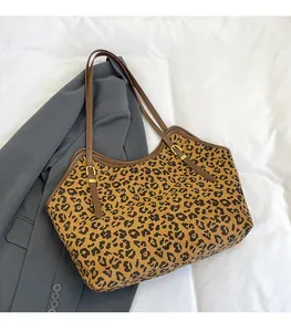 Dettaglio della borsa tote leopardata con bordo in pelle marrone e fibbia dorata