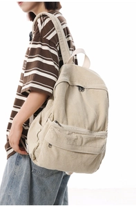 Detailed side view of the beige corduroy backpack texture and pocket on a female model
