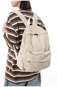 Detail of beige corduroy backpack texture and side pocket on a minimalist rucksack