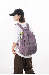 Detail view of purple corduroy backpack texture and side pocket on casual daypack
