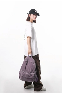 Full view of purple corduroy backpack with oversized white t-shirt and cargo pants