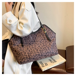 Dettaglio della borsa tote leopardata con cinturini in pelle nera e finiture metalliche oro