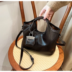 Dettaglio borsa vintage in pelle lucida testa di moro con ciondolo a lucchetto d'argento