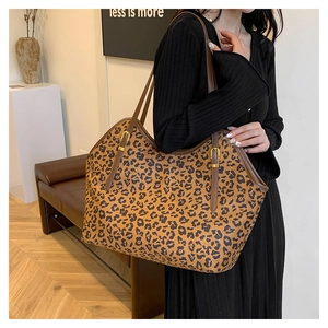 Dettaglio della borsa tote leopardata con manici in pelle marrone e fibbie dorate