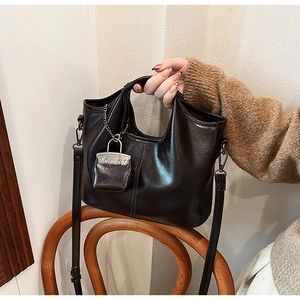 Dettaglio di borsa vintage marrone con ciondolo a lucchetto in metallo e tracolla