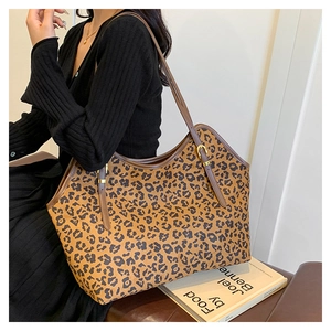 Dettaglio della borsa leopardata con tracolla in pelle marrone e fibbia dorata sulla spalla
