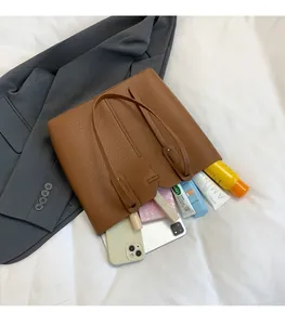 Vue détaillée du grand sac cabas marron en cuir grainé montrant une grande capacité intérieure