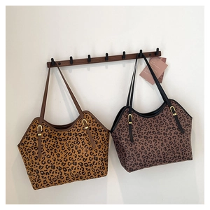 Dettaglio delle borse tote leopardate con lunghi cinturini in pelle e fibbie in metallo oro